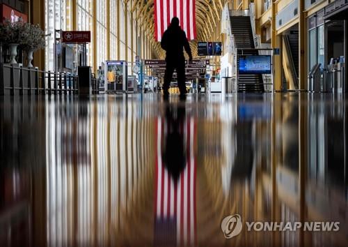 지난 12일 미국 버지니아주 알링턴의 로널드 레이건 워싱턴 내셔널 공항에서 한 직원이 텅 빈 통로를 지나고 있다. [연합뉴스 자료사진]