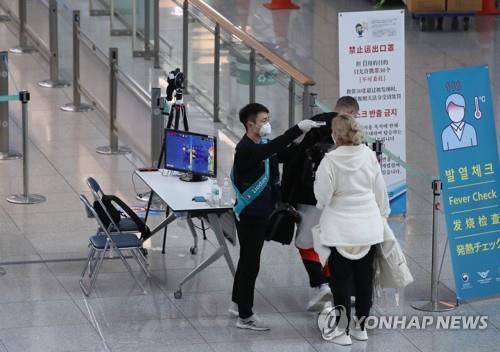 지난 3월 24일 인천국제공항 1터미널 출국장에서 출국하는 외국인이 발열 체크를 받고 있다. [연합뉴스 자료사진]