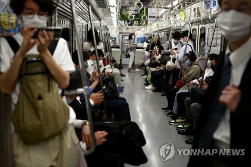 (도쿄 AFP=연합뉴스) 25일 일본 도쿄도(東京都)를 지나는 한 통근 열차에 승객들이 마스크를 쓰고 탑승해 있다. 2020.5.25