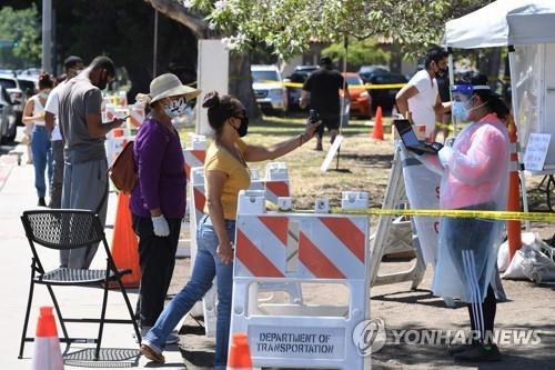 15일(현지시간) 미국 캘리포니아주 로스앤젤레스에 마련된 코로나19 검사소 앞에 사람들이 줄 서 기다리고 있다. [AFP=연합뉴스]