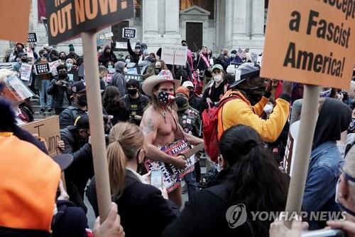 뉴욕서 시위대와 대치하는 트럼프 지지자 '벌거벗은 카우보이' (뉴욕 로이터=연합뉴스) 도널드 트럼프 미국 대통령 지지자이며 '벌거벗은 카우보이'(Naked Cowboy)로 알려진 로버트 버크(중앙)가 4일(현지시간) 뉴욕 맨해튼에서 열린 '모든 표를 집계하라' 집회에서 시위대와 대치하고 있다. 버크는 속옷 차림으로 카우보이 부츠ㆍ모자만 착용하고 미국 내 주요 도시의 도심에서 어쿠스틱 기타를 연주하면서 유명해진 인물이다. sungok@yna.co.kr