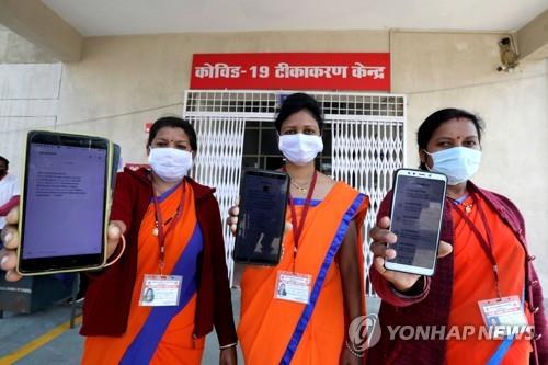 인도 보팔에서 코로나19 백신 접종 지원 앱 '코-윈'의 메시지를 보여주는 의료진. [EPA=연합뉴스]