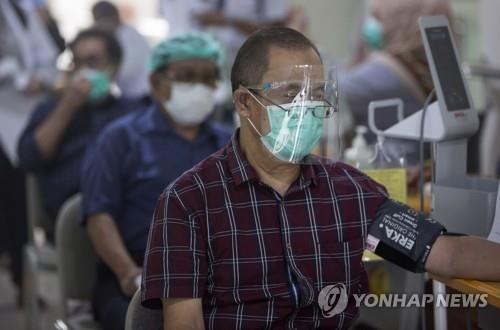 코로나19 백신 접종 전 검사하는 인도네시아 보건의료인