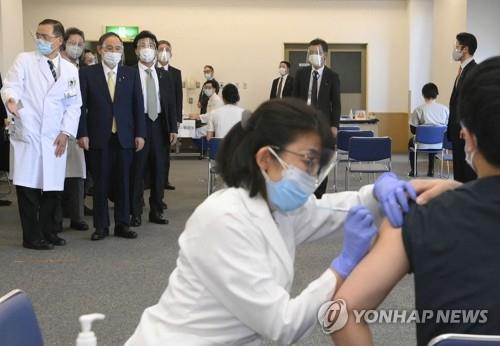 (도쿄 지지통신/AFP=연합뉴스) 스가 요시히데(위 왼쪽 2번째) 일본 총리가 지난 18일 국영 도쿄메디컬센터에서 코로나19 백신 접종 모습을 지켜보고 있다, 일본은 17일부터 화이자 백신으로 의료 종사자에 대한 선행접종을 시작했다.