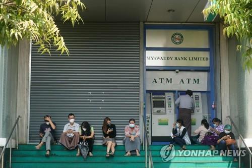 셔터를 내린 양곤 미야와디 은행의 ATM에서 현금을 찾는 시민들.[AFP=연합뉴스 자료사진]
