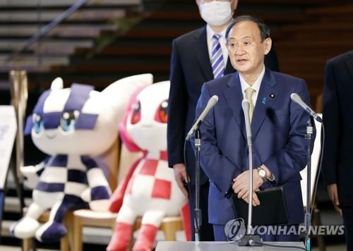 (도쿄 교도/로이터=연합뉴스) 스가 요시히데(菅義偉) 일본 총리가 10일 일본 총리관저에서 주요 7개국(G7) 정상회의 참석을 위해 영국을 향해 출발하기 전에 약식 회견을 하고 있다. 스가 총리 뒤쪽에 도쿄 올림픽·패럴림픽 마스코트 인형이 놓여 있다.