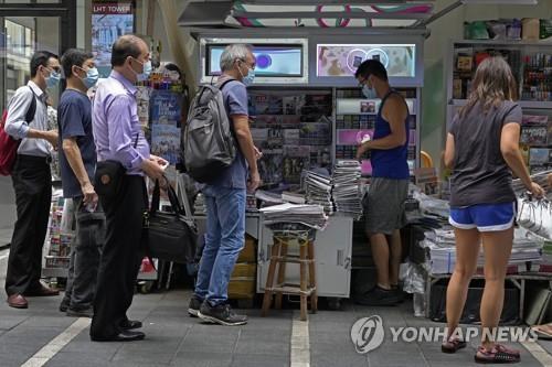 18일 홍콩 도심 한 신문 가판대에서 사람들이 빈과일보를 사기 위해 줄을 선 모습. [AP=연합뉴스]