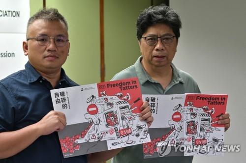 홍콩기자협회 현 회장 론슨 챈(왼쪽)와 전 회장 크리스 융이 15일 발간된 홍콩기자협회 연례보고서를 들어보이는 모습. [AFP=연합뉴스]