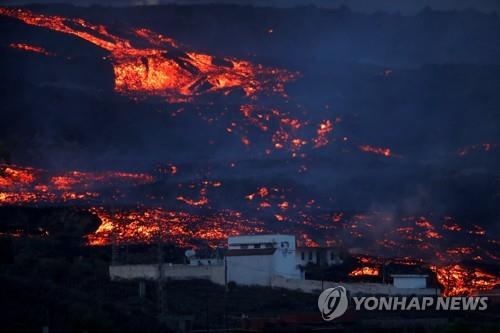 마을 뒤로 흐르는 뜨거운 용암