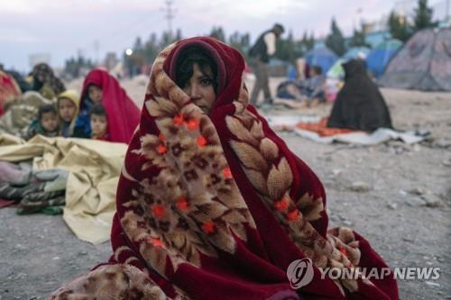  아프간 헤라트의 난민 캠프에서 담요를 덮고 있는 여성.