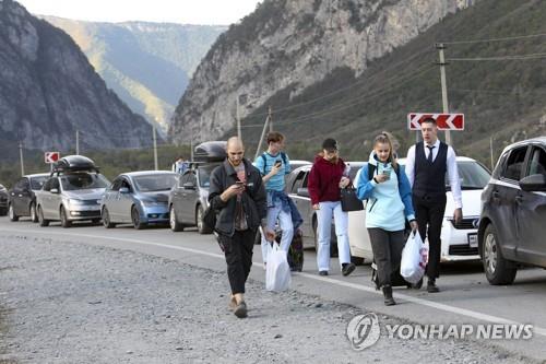 (베르흐니 라르스<러·조지아 국경> AP=연합뉴스) 러시아와 조지아간 국경 지역인 베르흐니 라르스에서 28일 국경을 넘으려는 차량들이 긴 줄을 서 있는 가운데 일부 러시아인들이 도보로 국경검문소로 향하고 있다. 2022.09.28