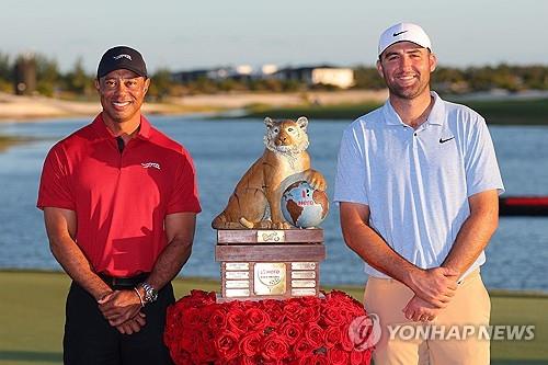 대회 주최자 타이거 우즈와 함께 우승 트로피 옆에 선 셰플러.