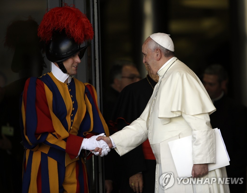 지난 10월 가톨릭 세계주교대의원회의(주교 시노드)가 열리는 회의장에 도착한 프란치스코 교황이 근위병과 악수하고 있다. (AP=연합뉴스) 