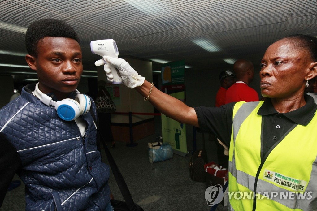 (AP=연합뉴스) 20일(현지시간) 나이지리아 라고스의 무르탈라 모하메드 국제공항 입국장에서 보건요원이 승객의 체온을 측정하고 있다.