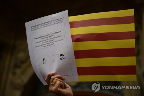 카탈루냐 분리독립 지지 집회 참가자가 들고 있는 모조 투표용지