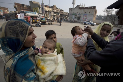 18일 파키스탄 카수르에서 주민들이 어린 자녀들에게 소아마비 예방접종을 하고 있다.[AP=연합뉴스]