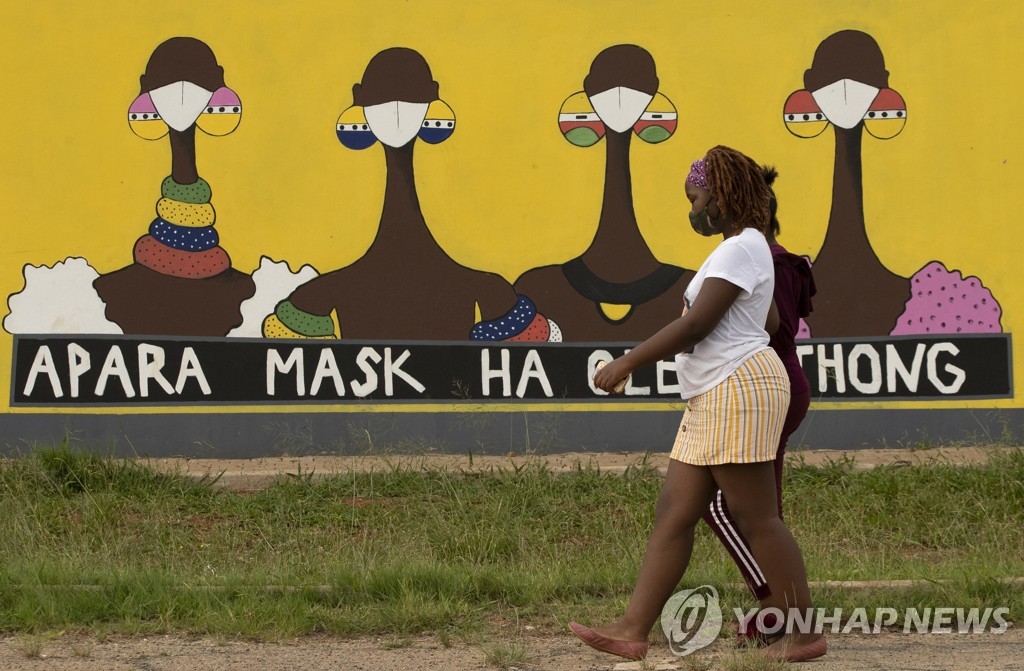 지난 1월 남아프리카공화국에서 한 여성이 마스크 착용을 강조하는 벽화를 지나치고 있다.