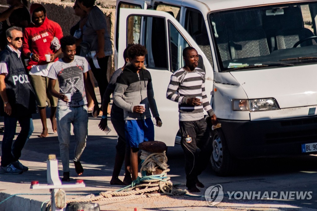 2019년 8월 17일 스페인 구호단체 '오픈암즈'(Open Arms) 소속 난민 구조선에 타고 있던 난민 134명 중 동반자가 없는 미성년자 27명이 이탈리아 남부 람페두사섬에 상륙해 경찰의 인도를 받고 있다. [AFP=연합뉴스]