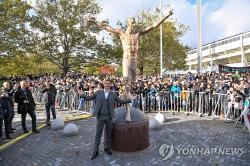스웨덴 말뫼에 세워진 자신의 동상 앞에서 포즈를 취한 이브라히모비치.