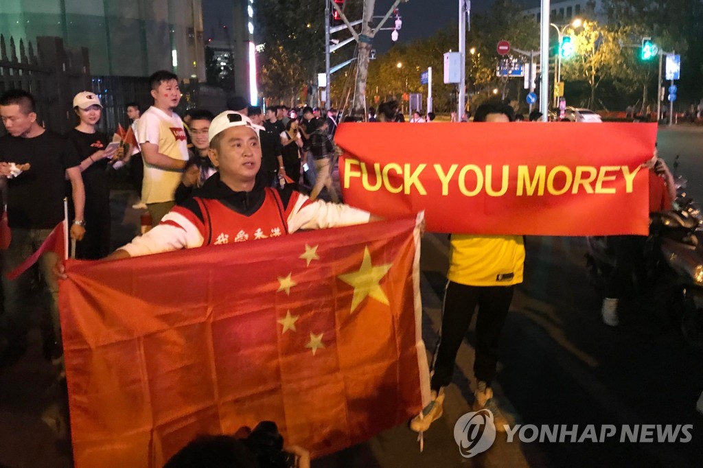 10일 상하이에서 NBA 시범경기 전에 사람들이 대릴 모리 휴스턴 로키츠 단장에 항의하는 현수막과 중국 국기를 들고 있다. [AFP=연합뉴스]
