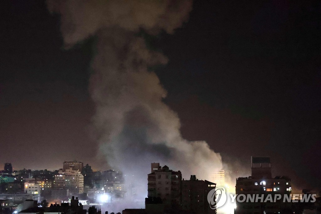 12일(현지시간) 이스라엘군 공습을 받은 팔레스타인 가자지구 한 건물에서 흰 연기가 피어오르고 있다. [AFP=연합뉴스]