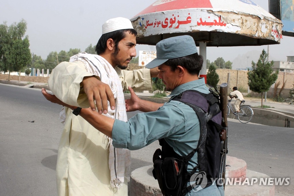 탈레반 지도자 물라 무하마드 오마르의 사망이 알려진 29일 아프가니스탄 칸다하르에서 치안당국이 길에서 한 남성의 몸을 수색하고 있다.(EPA=연합뉴스)