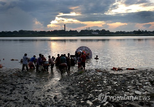 지난해 10월 인도 동부 웨스트벵골 주 콜카타에서 두르가 푸자 축제 마지막 날 힌두 신자들이 두르가 여신상을 갠지스 강에 입수시키고 있다.[EPA=연합뉴스 자료사진]