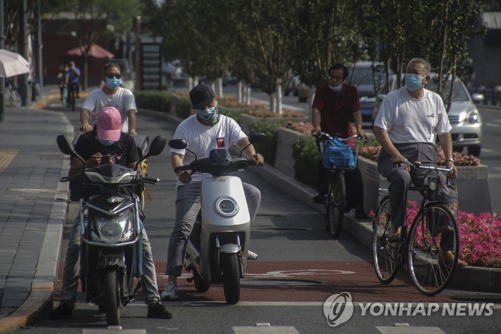 6일 베이징에서 마스크를 쓰고 스쿠터와 자전거를 탄 사람들 [EPA=연합뉴스]