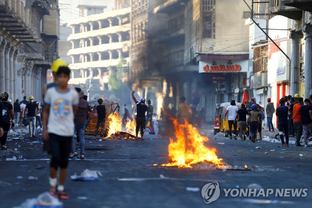 9일(현지시간) 이라크 바그다드 시내에서 반정부 시위대가 진압 부대를 향해 화염병을 던지고 있다.