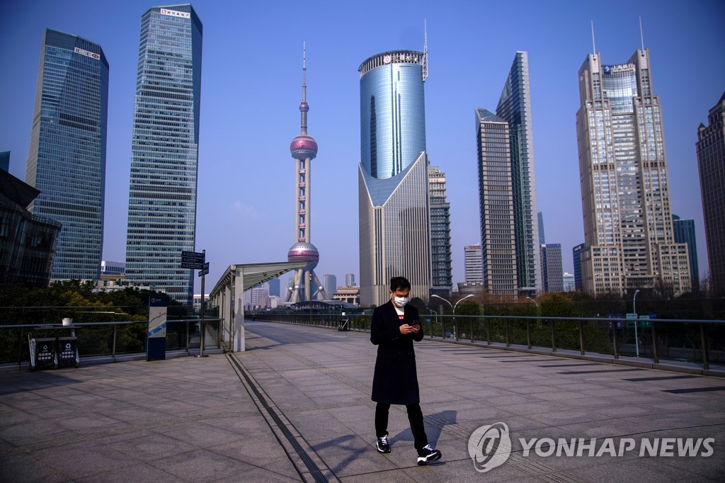 FILE PHOTO: A man wearing a mask is seen at Lujiazui financial district in Pudong, Shanghai, China, as the country is hit by an outbreak of a new coronavirus, February 3, 2020. REUTERS/Aly Song/File Photo