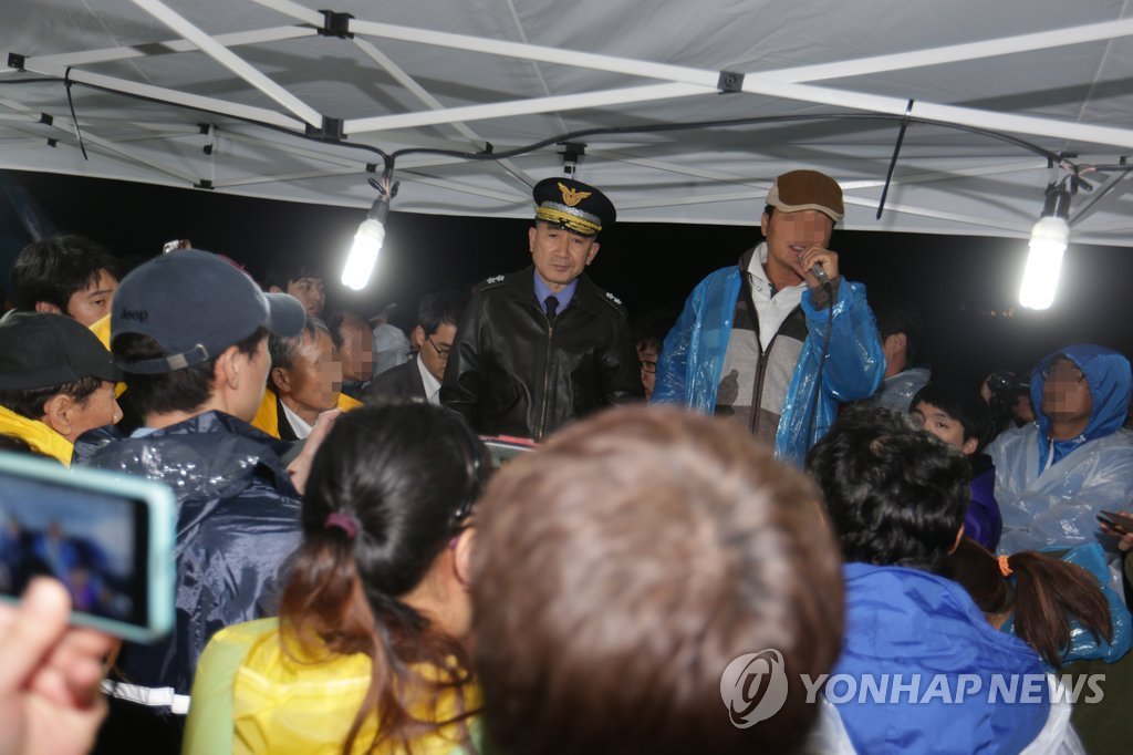 김수현 서해해경청장(가운데)이 17일 밤 전남 진도군 팽목항에서 열린 실종자 가족 면담에서 항의를 받자 난감한 표정을 짓고 있다. 