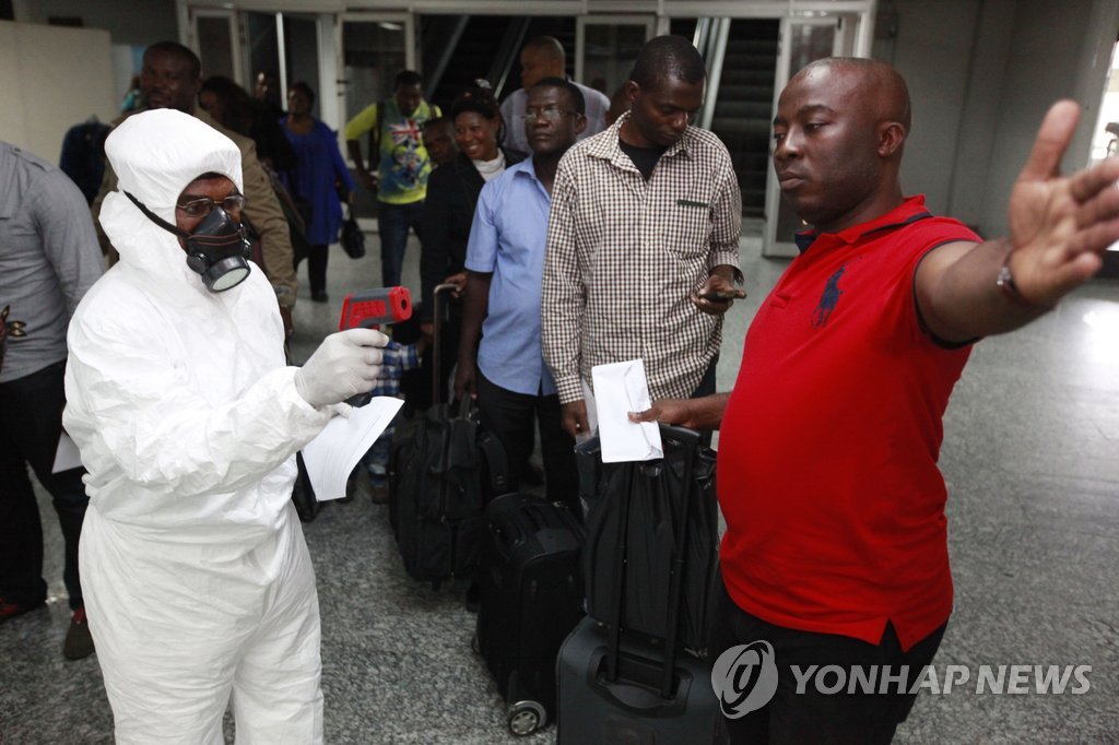 
서 아프리카에 에볼라 비상이 걸린 가운데 6일(현지시간) 나이지리아의 수도 라고스 국제공항 입국장에서 검역요원이 승객들의 체온 측정에 나서고 있다. (AP/선데이 알람바=연합뉴스) 