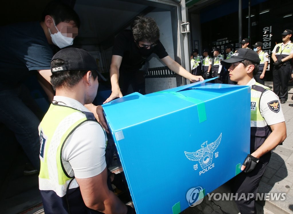 지난 15일 경찰이 '자주통일과 민주주의를 위한 코리아연대' 사무실에서 압수수색한 물품을 옮기고 있다. (연합뉴스 자료사진)