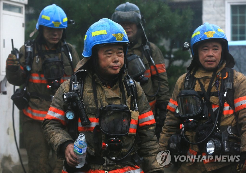 검게 변한 얼굴의 소방관들