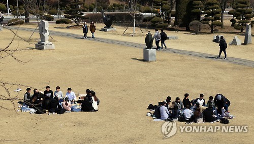캠퍼스 잔디밭에 둘러 앉은 대학생들