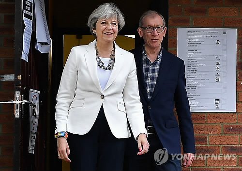 (런던 AFP=연합뉴스) 영국 조기총선 투표가 8일 오전 7시(현지시간) 시작된 가운데 테리사 메이 총리가 남편 필립과 함께 런던에서 투표를 마친 후 밖으로 나오고 있다.