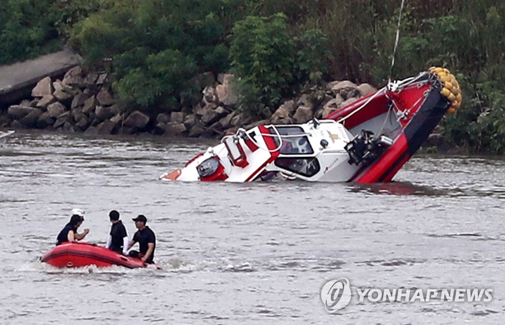 This photo shows the rescue boat that carried two missing firefighters being recovered from the lower Han River on Aug. 13, 2018, near Gimpo Bridge in the same city, just west of Seoul. (Yonhap)