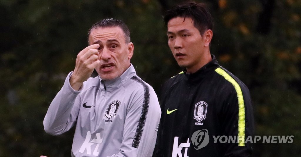 This file photo taken on Sept. 3, 2018, shows South Korea national football team defender Kim Young-gwon (R) and head coach Paulo Bento during training at the National Football Center in Paju, north of Seoul. (Yonhap)