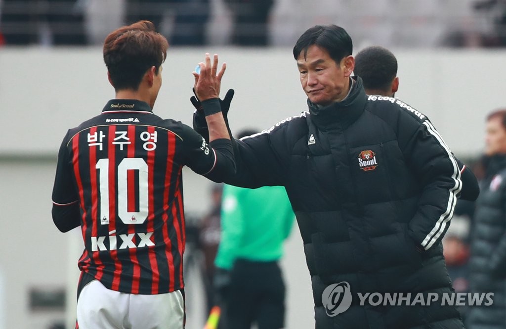 FC Seoul head coach Choi Yong-soo (R) high-fives Park Chu-young during a K League promotion-relegation playoff match against Busan IPark FC in Seoul on Dec. 9, 2018. (Yonhap)