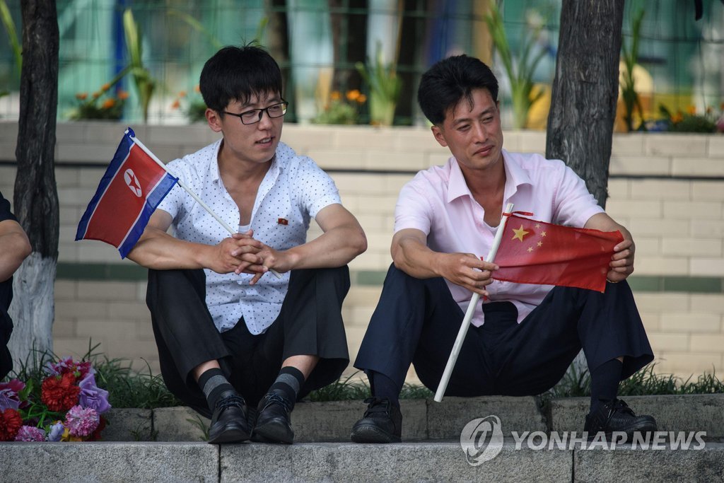 北인공기와 中오성홍기 손에 든 북한 주민들