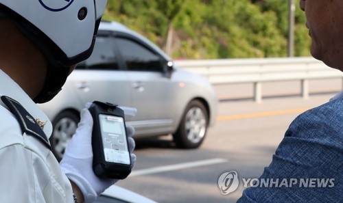 (춘천=연합뉴스) 양지웅 기자 = 강화된 음주단속 기준을 적용하는 이른바 '윤창호법' 시행 첫날인 25일 오전 강원 춘천시 거두리의 도로에서 한 운전자가 음주단속에 적발돼 재측정을 하고 있다. 이 운전자는 전날 저녁 소주 2병을 마셨다고 경찰에 진술했다. 2019.6.25 yangdoo@yna.co.kr