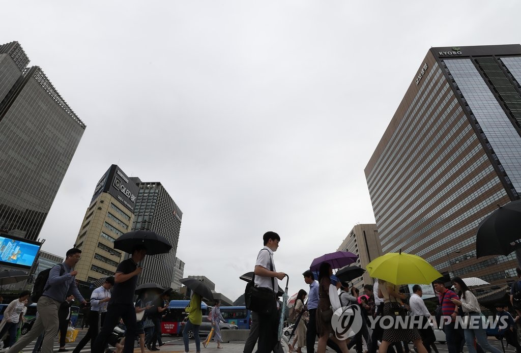 우산을 든 출근길 시민들이 서울 광화문네거리를 지나고 있다. 