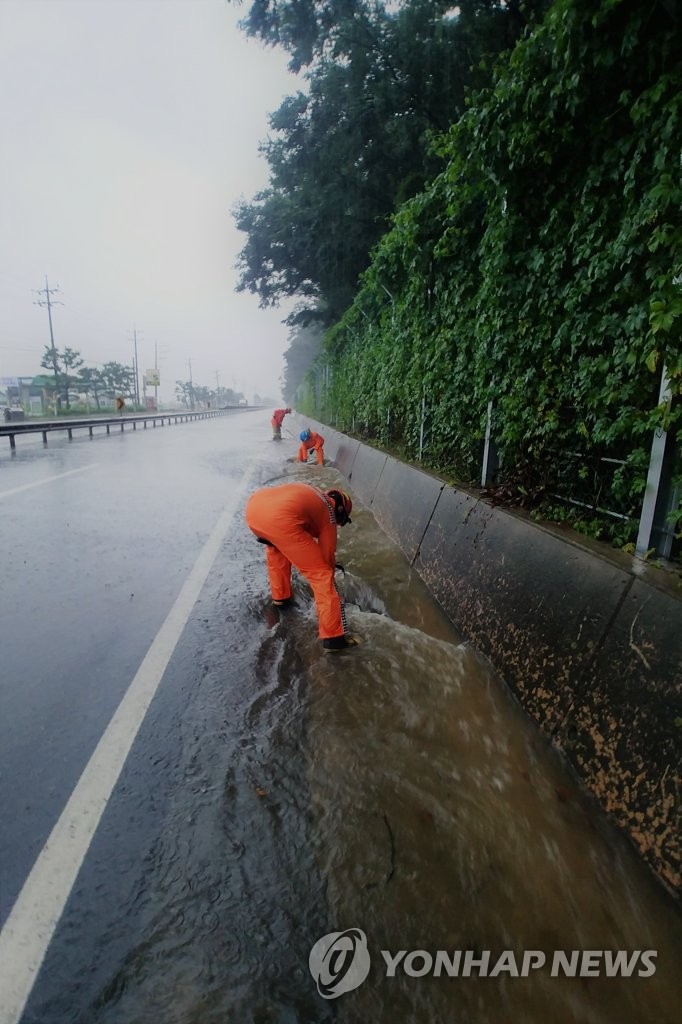 Firefighters work to restore inundated road Firefighters work to restore inundated road