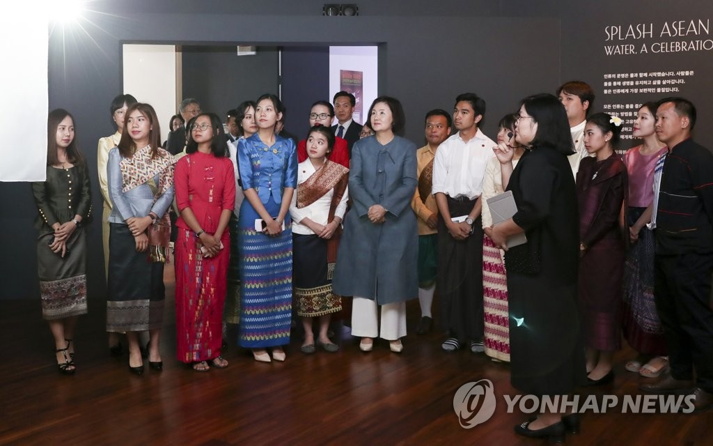김정숙 여사가 지난 8월 부산 아세안문화원을 찾아 유학생들과 전시작품을 관람하고 있다.