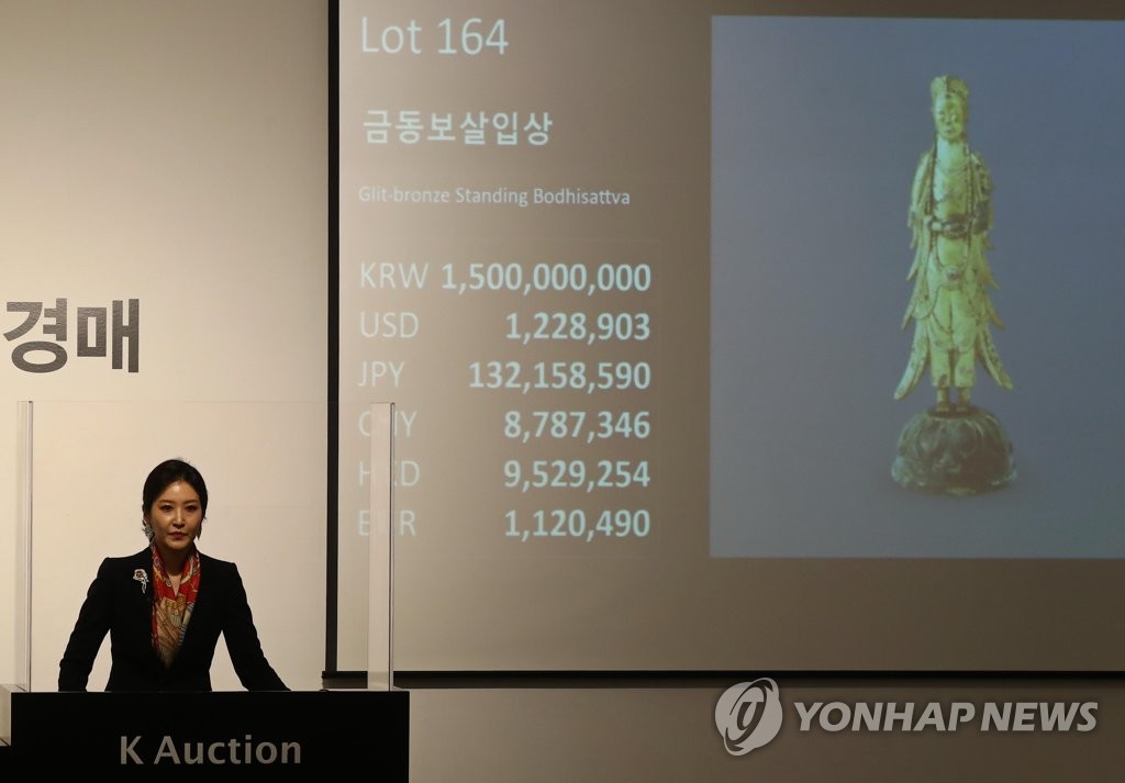 An auctioneer presents Gilt-bronze Standing Bodhisattva, which was made between the 6th and 7th centuries during the Silla period, at an auction event held at K Auction in southern Seoul on May 27, 2020. (Yonhap)