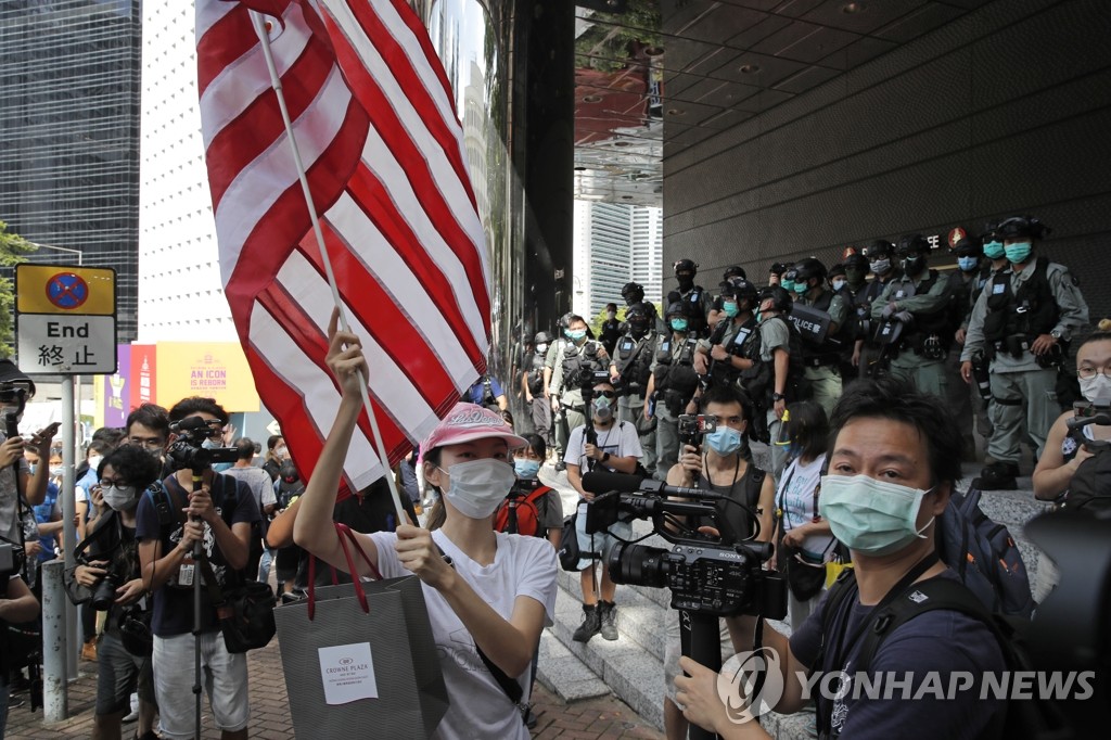 홍콩 경찰들 앞에서 성조기를 들고 있는 여성