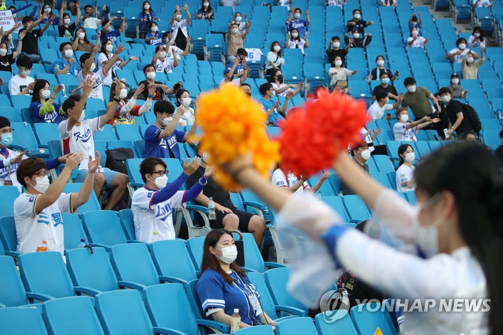 Wearing masks, baseball spectators cheer while adhering to social distancing guidelines as they watch a game between the Hanwha Eagles and the Samsung Lions in the southeastern city of Daegu on July 29, 2020. (Yonhap)