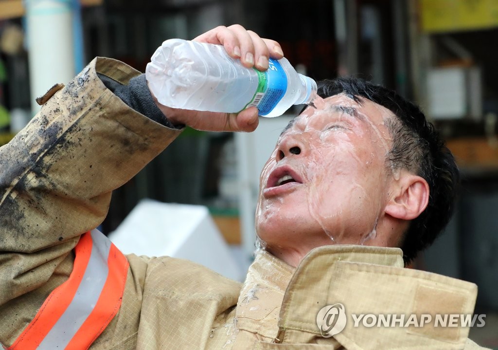 무더운 날씨에 화재진압 마친 소방대원들