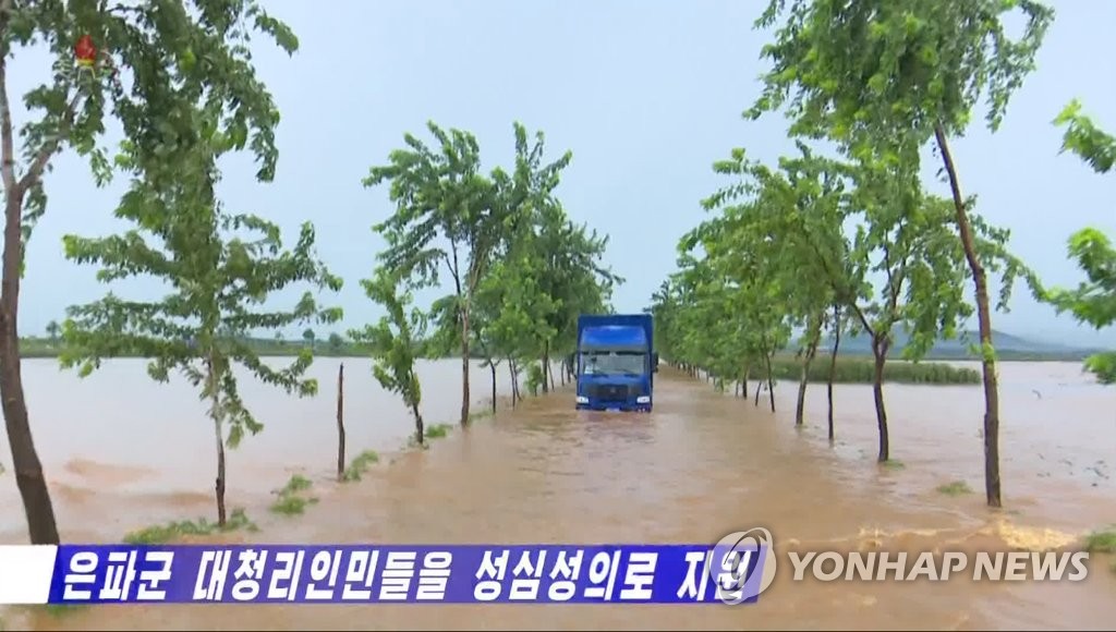 지난해 폭우에 침수된 도로 달리는 북한 수해지역 지원 트럭