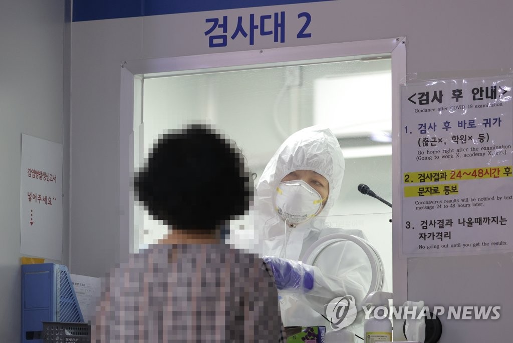 A medical staff member collects samples to carry out new coronavirus tests at a makeshift clinic in Seoul on Aug. 24, 2020. (Yonhap)